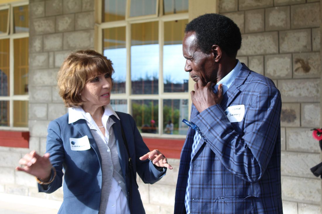 Pastor Sammy, founder of Merciful International Guild, speaking with a visiting volunteer